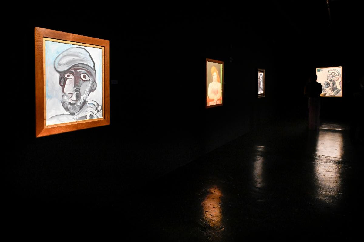 Installation view of Picasso portraits in a dark gallery at Gary Nader Art Centre.