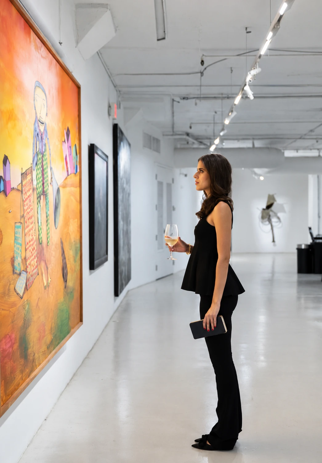 A visitor looking at a painting during Visual Rhythms at Gary Nader Art Centre.