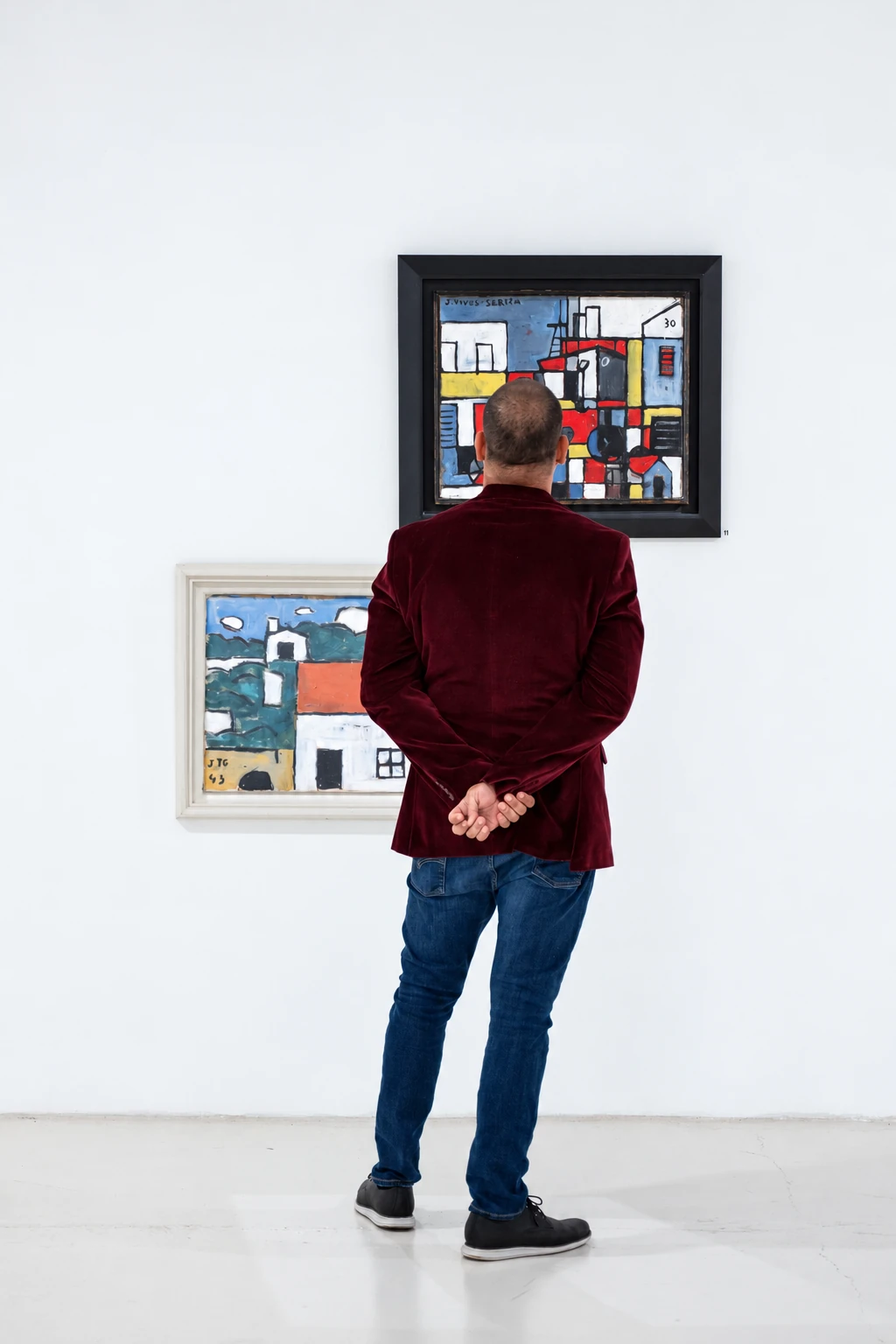 A visitor studying paintings in the Visual Rhythms exhibition.