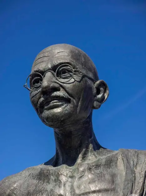 Close-up of a bronze sculpture’s face against a blue Miami sky.