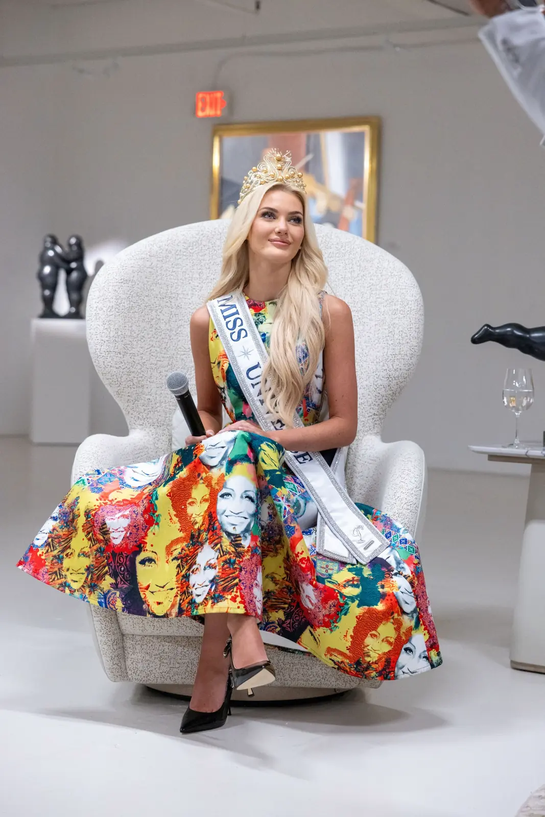 Miss Universe 2024 Victoria Kjær Theilvig seated with a microphone at Gary Nader Art Centre.